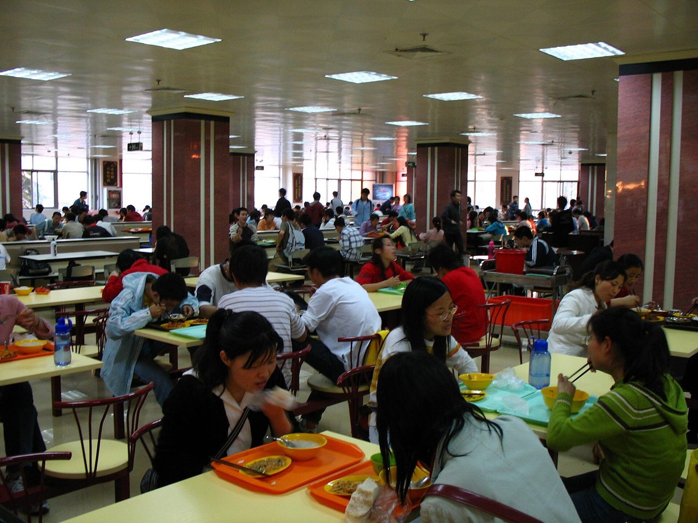 Students eating lunch together at a university canteen dining hall in China