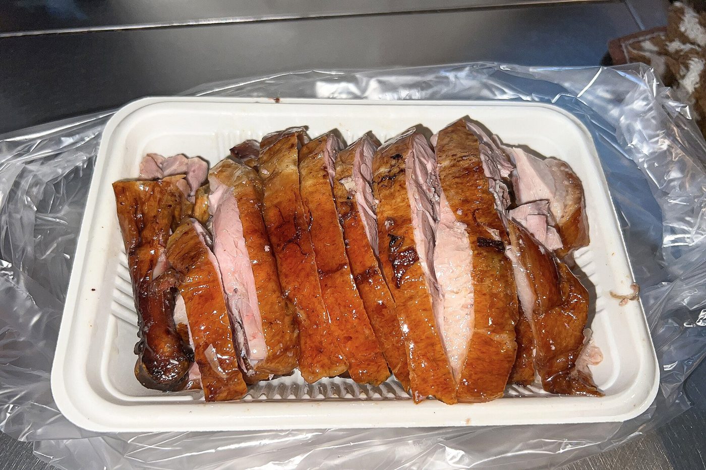 A whole roast duck glistening on a plate, the dish at the heart of China's Chushu custom of eating duck.