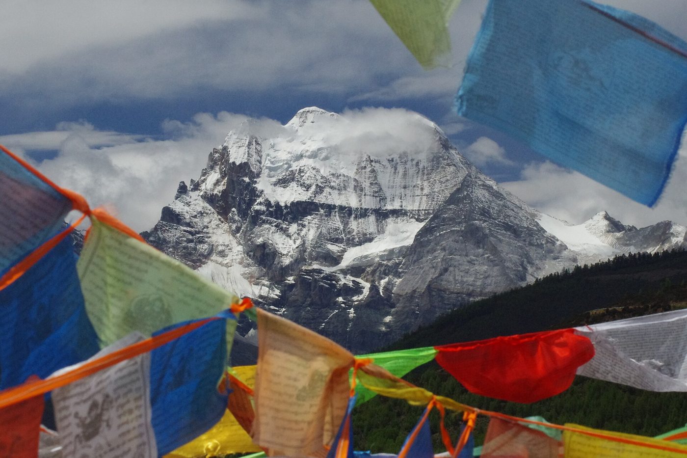 Snow-capped sacred peak of Xiannairi rising above a green valley in the Yading Nature Reserve, Sichuan