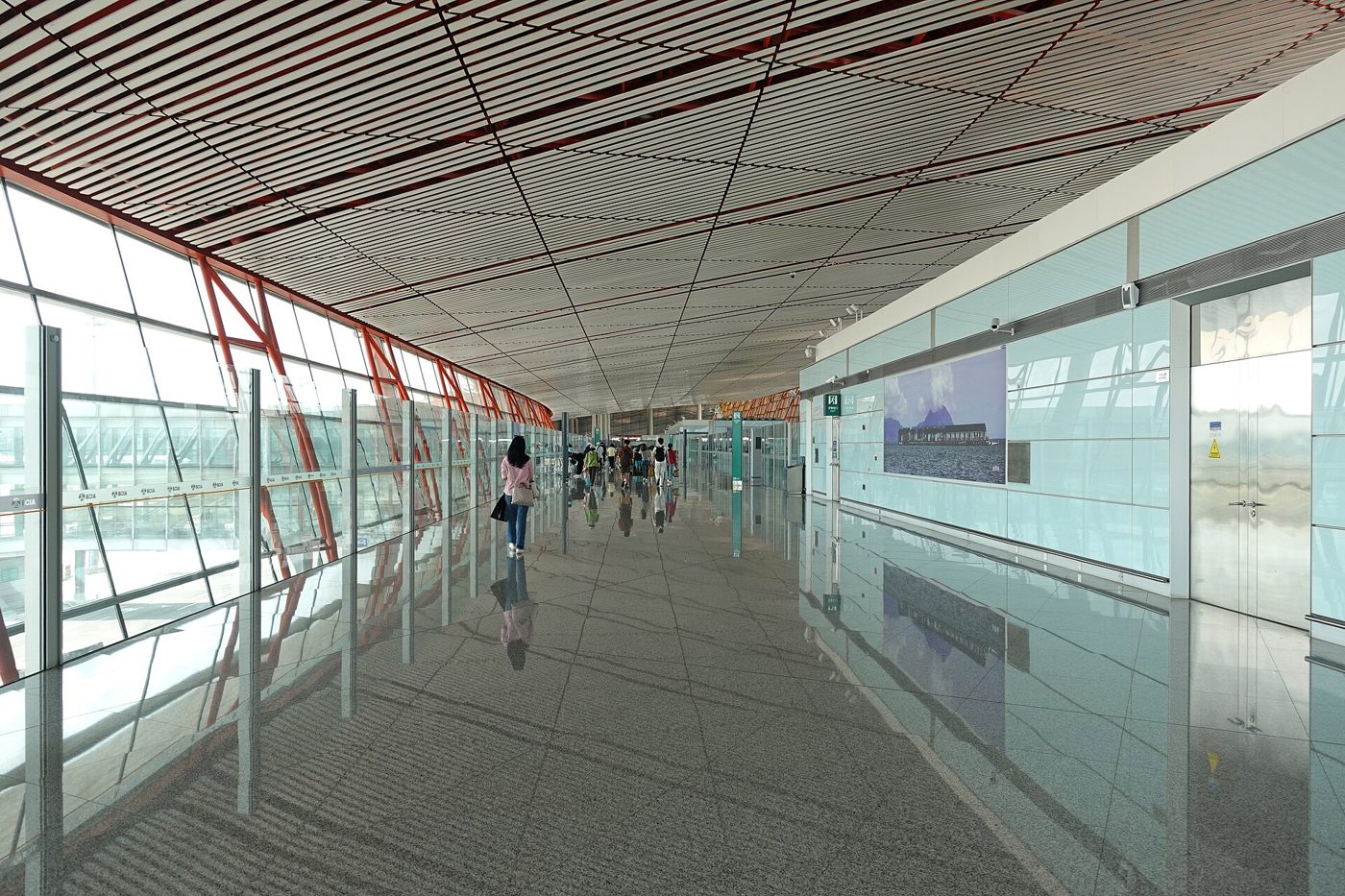 Travellers walking through the international arrivals corridor at Beijing Capital International Airport Terminal 3.