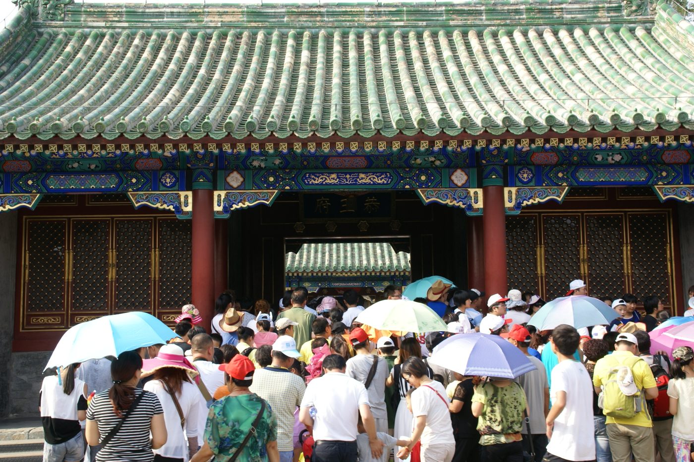 A courtyard view inside Prince Gong's Mansion in Beijing, showing traditional grey-tiled rooflines and garden walkways.