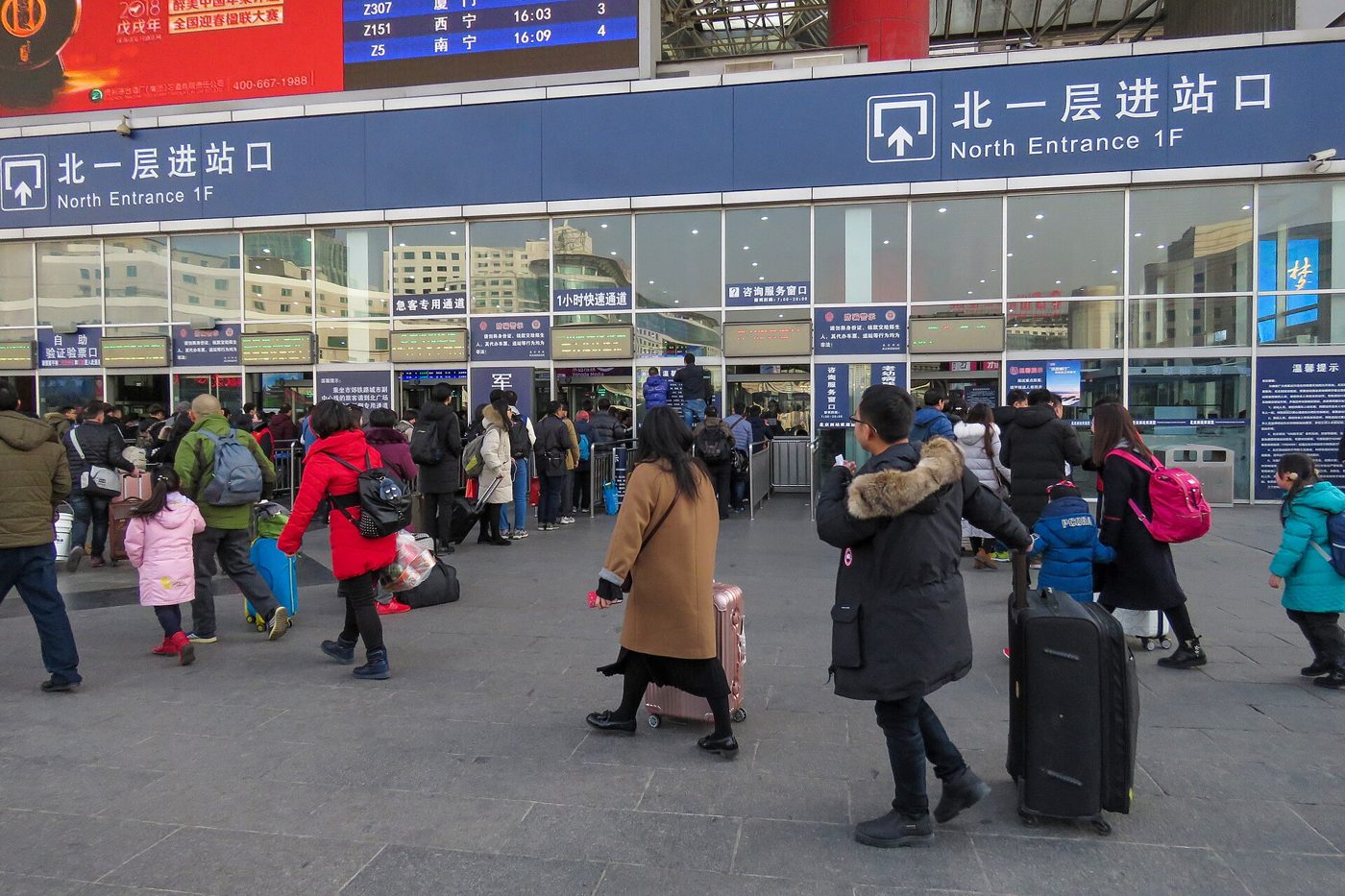 Travellers filling the entrance hall of Beijing West railway station