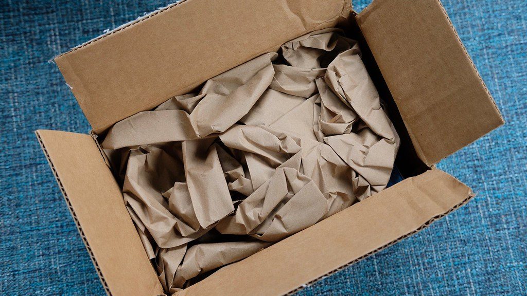 An open cardboard shipping box with packing paper, standing in for the flood of delivery packages that arrive during China's online shopping festivals.