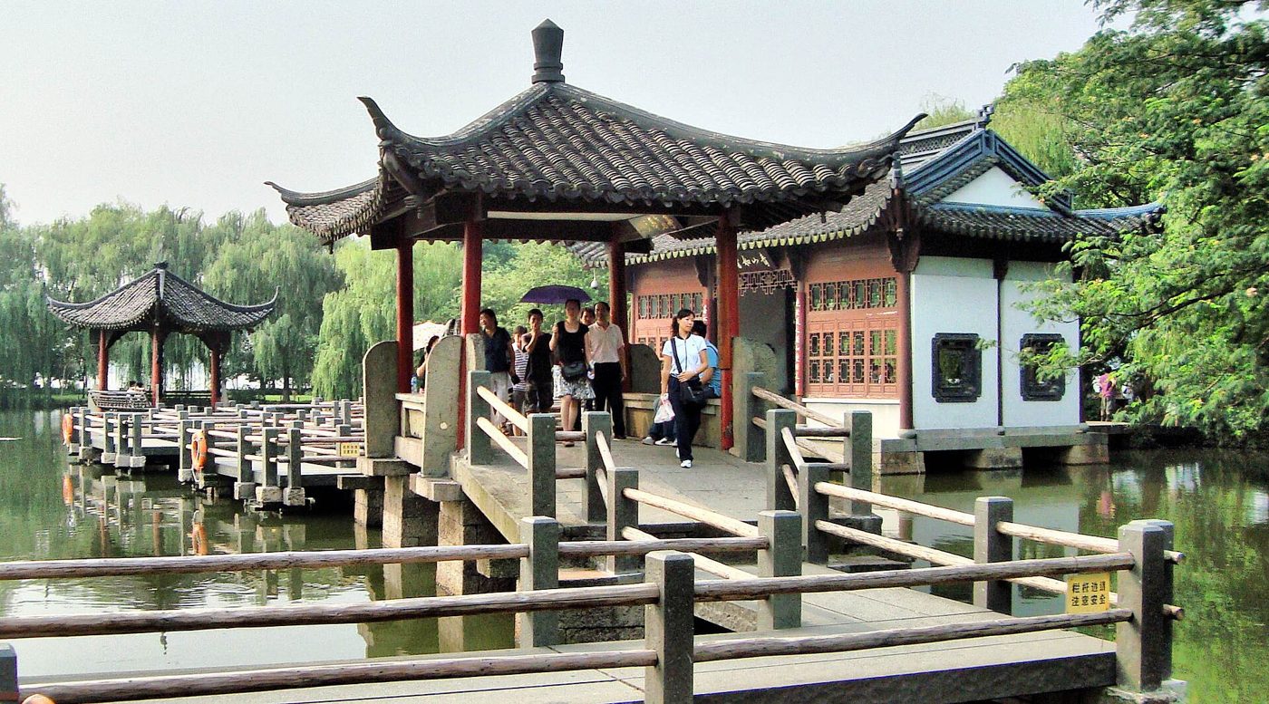Hangzhou's West Lake in autumn, with the lake, trees, and buildings in the distance
