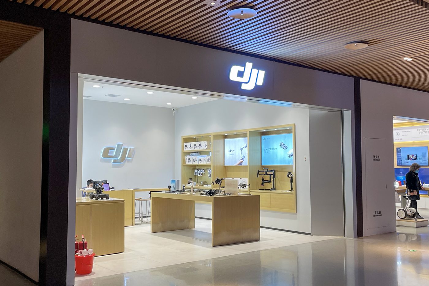 A DJI store in a Chinese shopping mall, its counters laid out with drones and gimbals