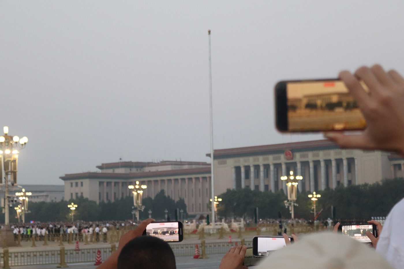 Soldiers of the flag guard raise the five-star red flag at dawn on Tiananmen Square as crowds watch