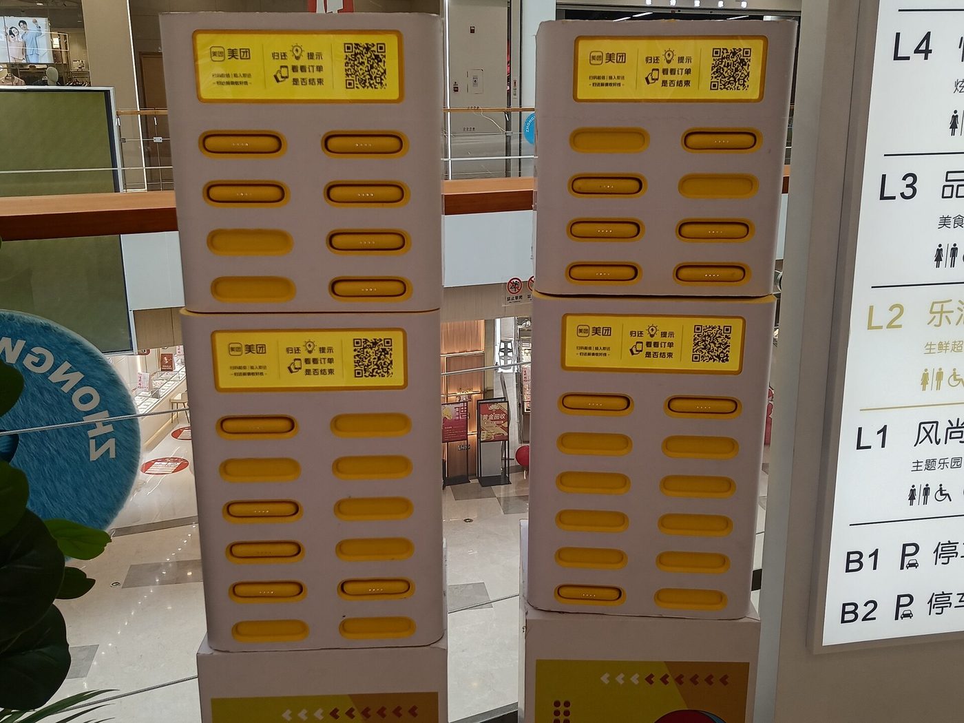 A row of yellow Meituan-branded power banks charging in a shared power bank rental cabinet