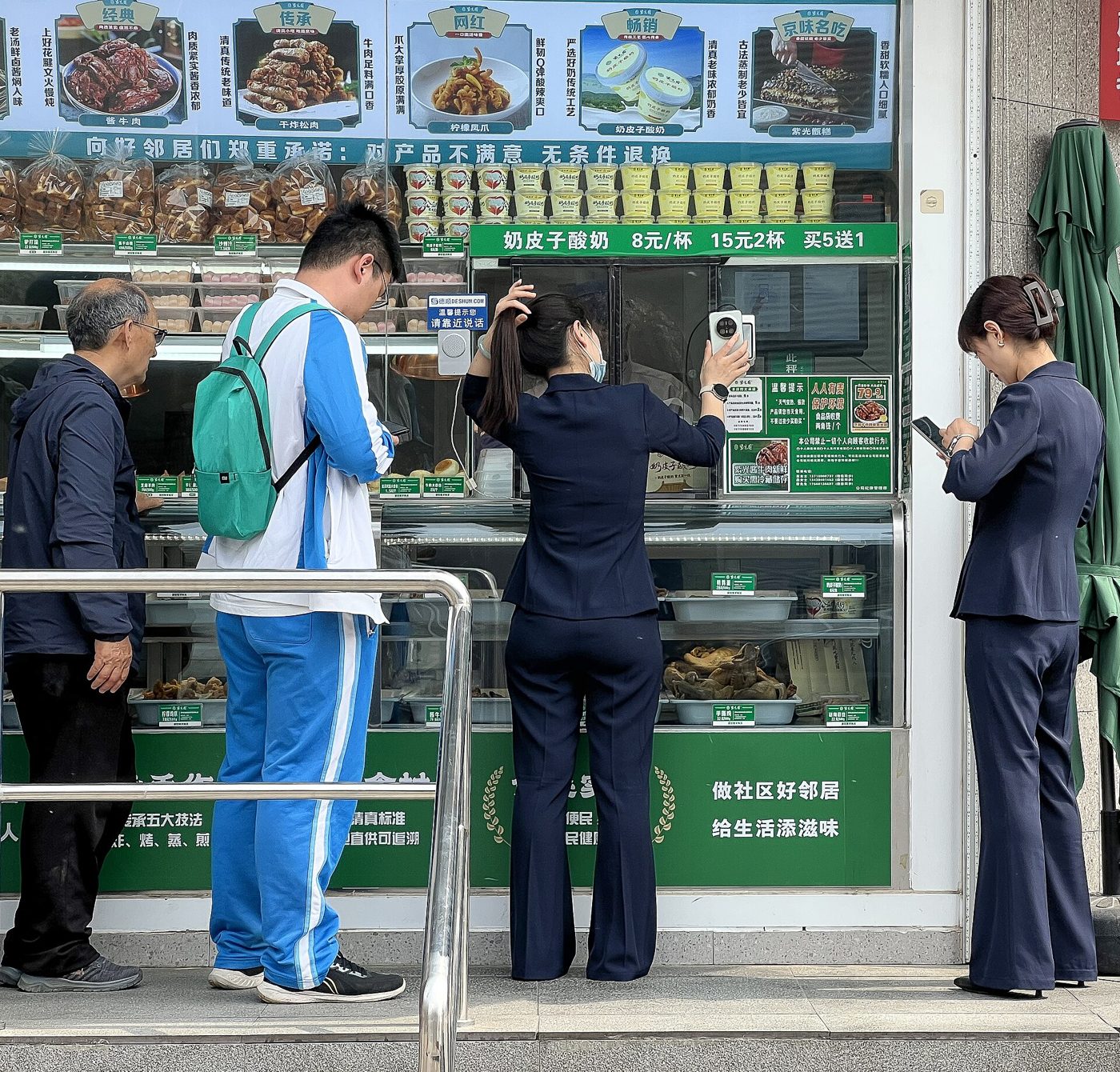 A customer holds up her phone to show a payment QR code to a shopkeeper in China.