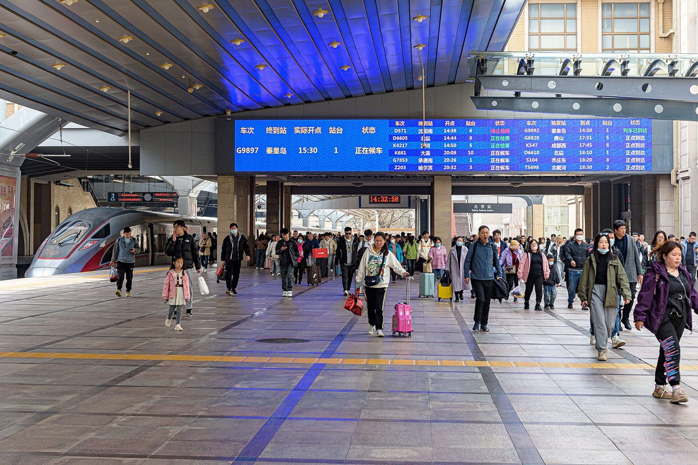 Passengers walk along a crowded platform at Beijing Railway Station
