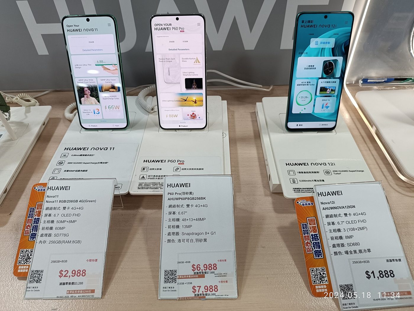 香港一家电器店里，三部华为手机立在展示台上，旁边摆着写有价格的卡片。
