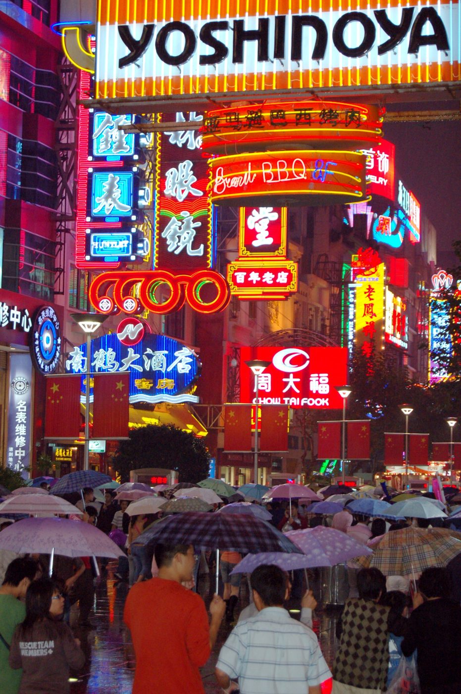 A street of neon shop signs in the rain