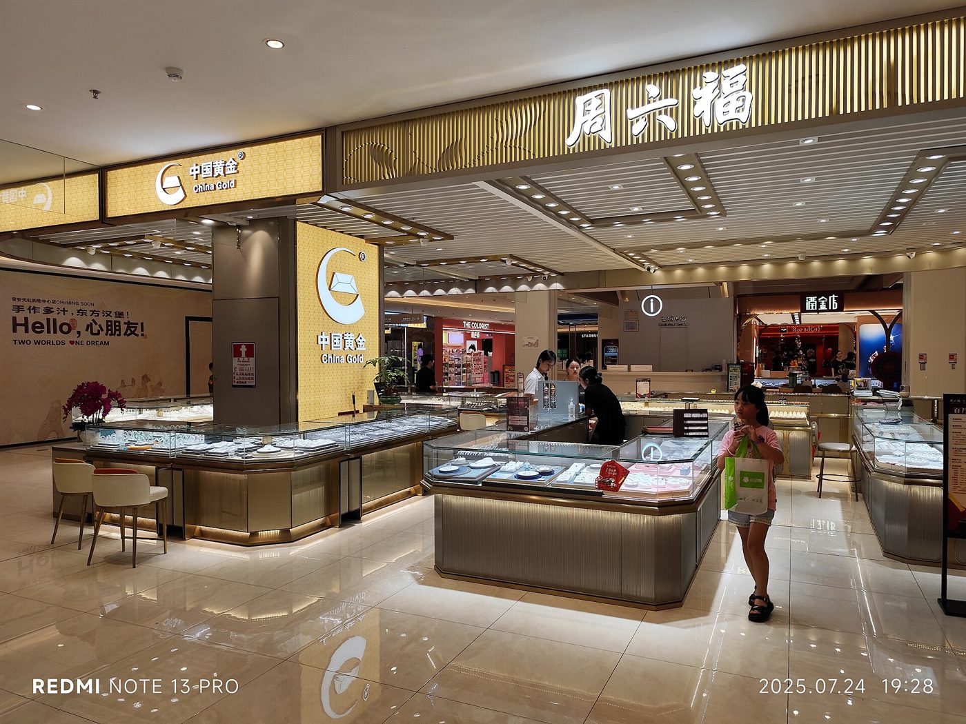 A brightly lit gold jewelry shop front in a Shenzhen shopping mall at night