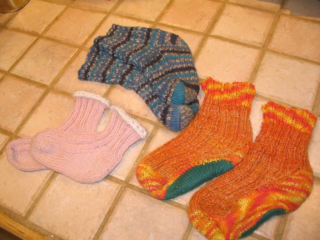 Three pairs of colorful children's socks laid out together on a table.