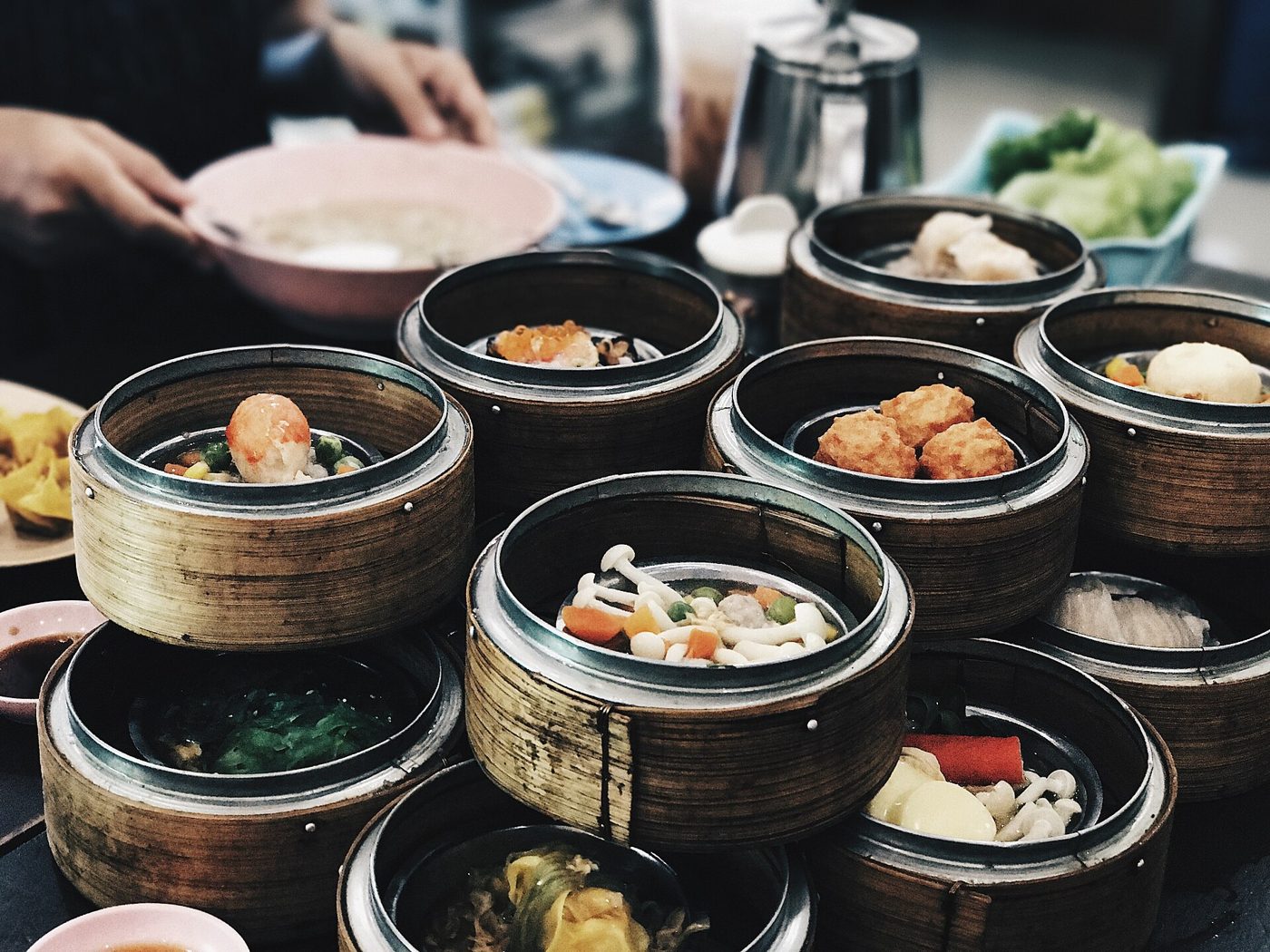A table set with several small steamer baskets and plates of Chinese morning-tea dim sum dishes