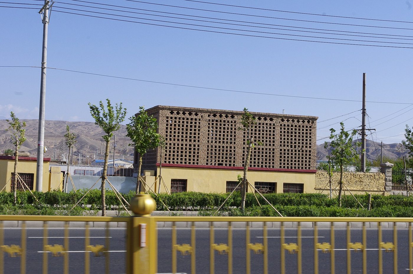 A traditional raisin-drying house in Turpan, its upper walls built as a lattice of small square openings in mud brick to let the dry desert wind through.