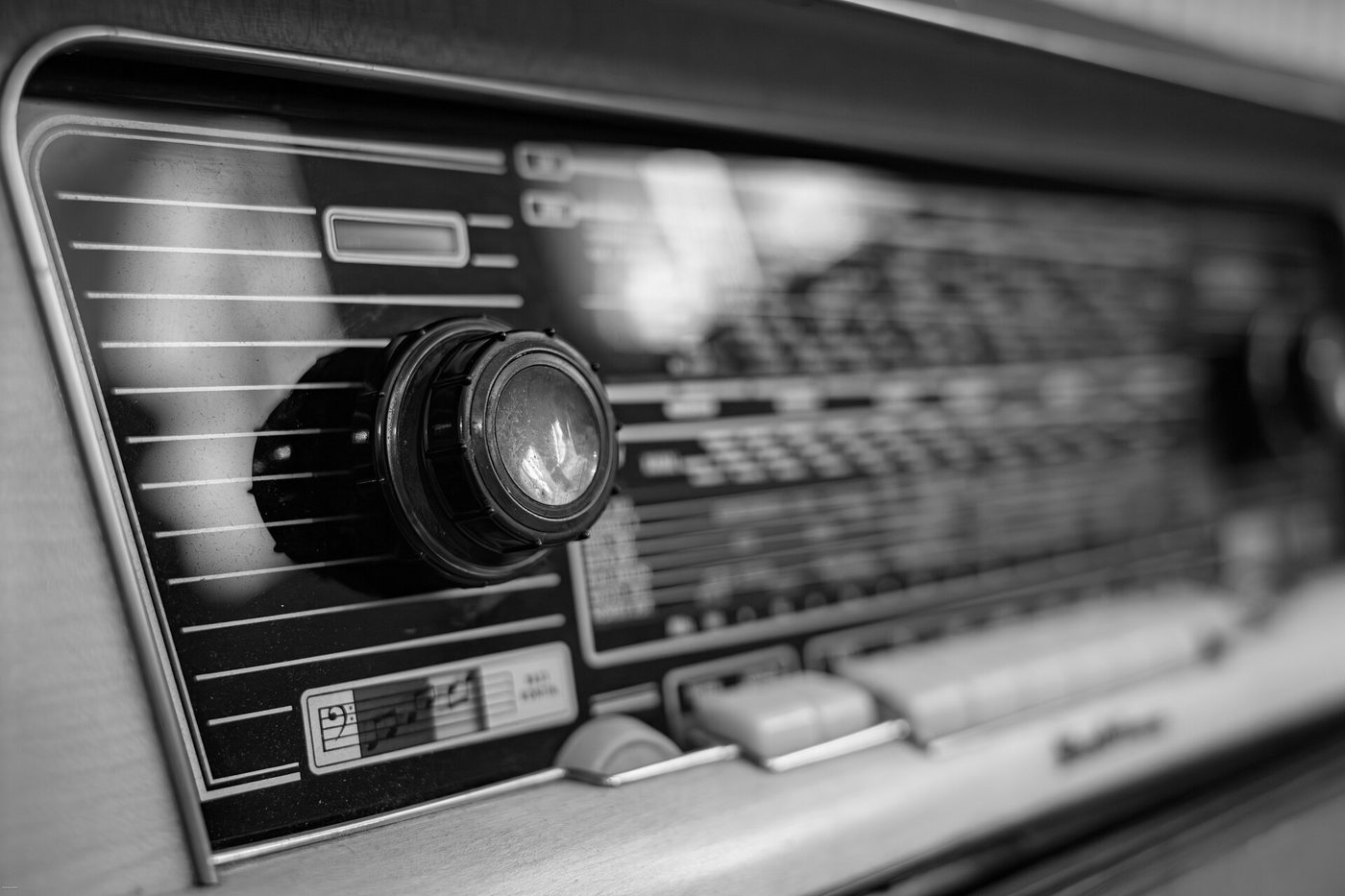 A vintage wood-cabinet radio with a round tuning dial, photographed from the front.