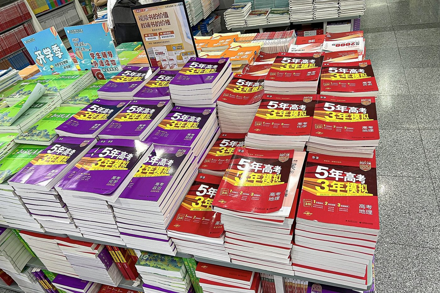Stacks of school workbooks piled on shelves at a bookstore in Beijing