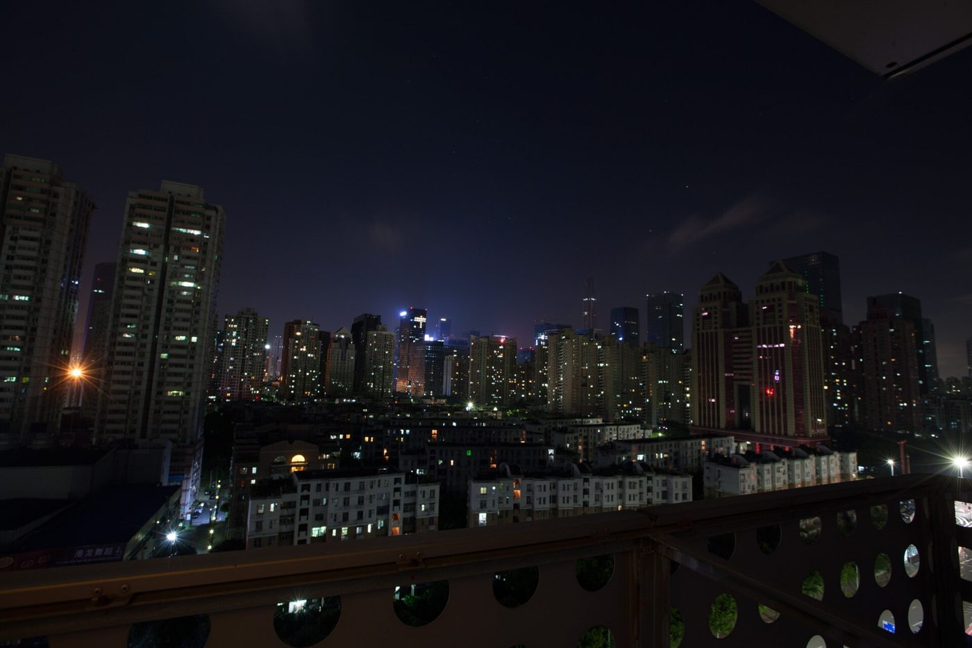 Shenzhen's skyline lit up at night, rows of illuminated skyscrapers with no moon visible in the sky above.