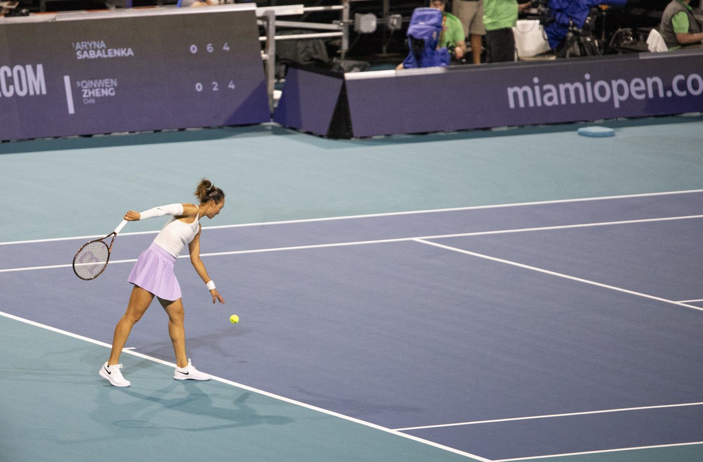 Zheng Qinwen hitting a return shot during a hard-court match at the 2025 Miami Open.