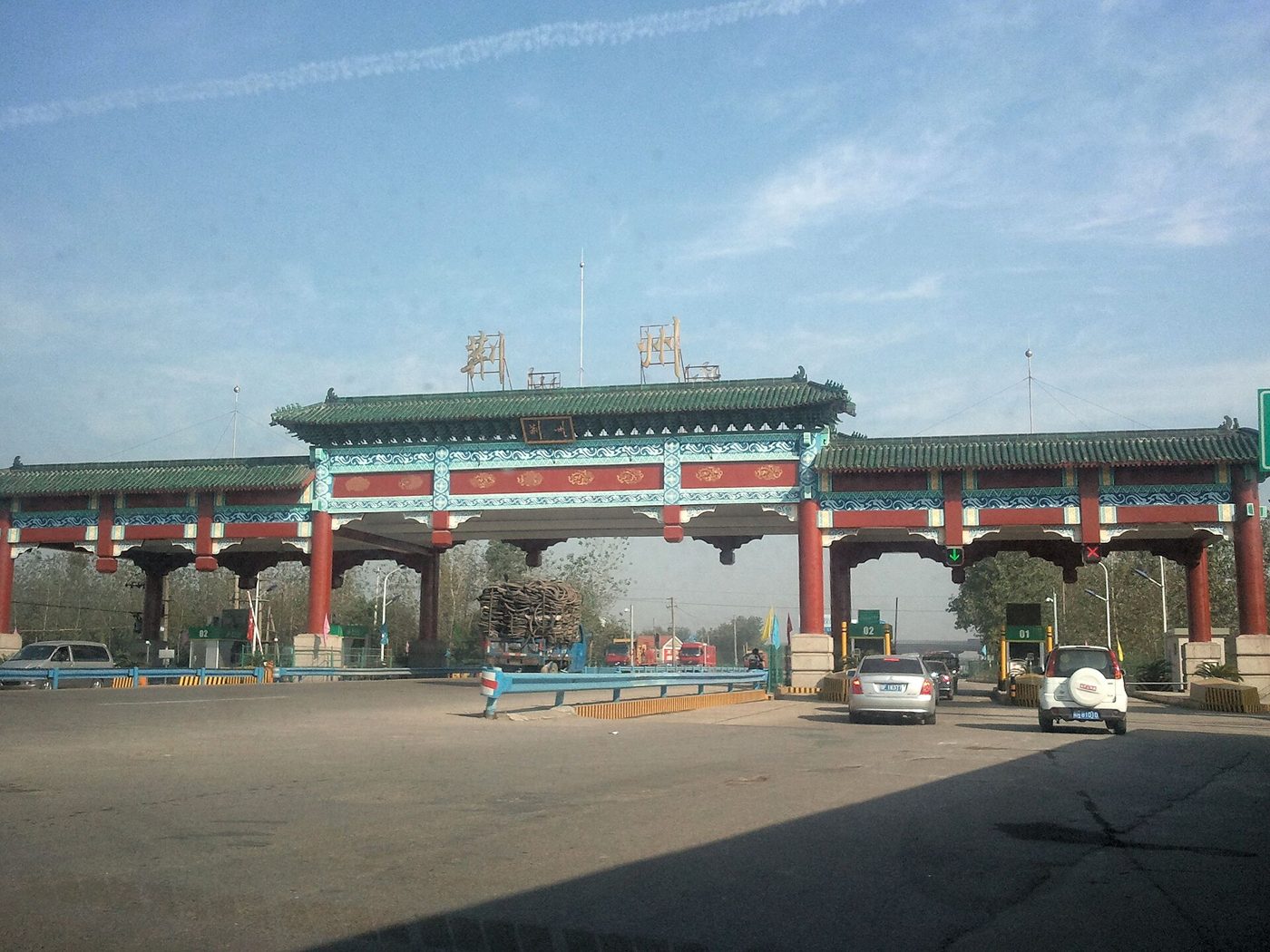 A toll booth on a Chinese expressway, with a car passing through one of the payment lanes.